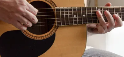 Epiphone acoustic guitar resting against an amplifier