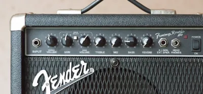 Close-up of a guitar amplifier control panel showing the gain, bass, treble, and volume knobs
