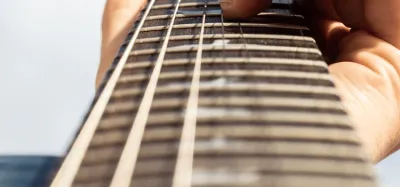 Guitar fret wrap fitted around the neck to mute strings near the nut