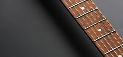 Checking a guitar neck for bow by sighting a straightedge along the fretboard