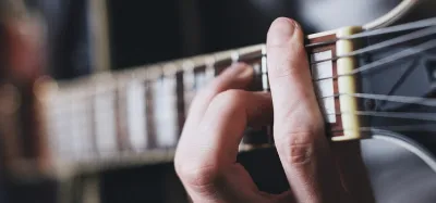 Close-up of three guitar necks showing C, V, and U back profiles side by side