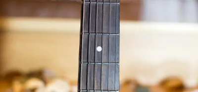 Close-up of a guitar neck and headstock with strings tuned up under tension