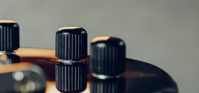 Close-up of the volume and tone potentiometers inside an electric guitar