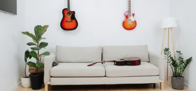 Home guitar practice room with a guitar on a stand, amp, and music stand