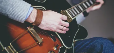 Hands strumming an acoustic guitar