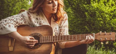 Beginner guitarist practicing chords on an acoustic guitar