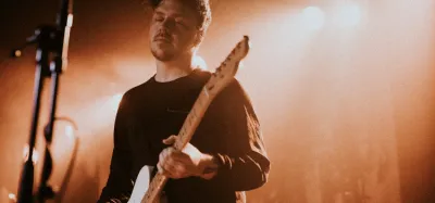 Guitarist playing through a lightweight combo amp at a live gig
