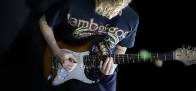 Expert guitarist playing a fast, difficult solo on an electric guitar
