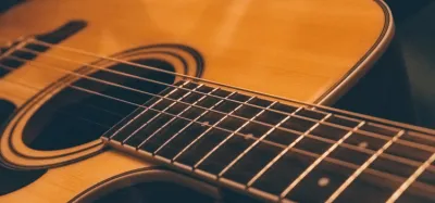 Ed Sheeran performing solo with an acoustic guitar and a loop pedal on stage