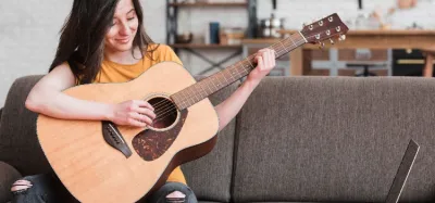 Beginner learning to play guitar at home