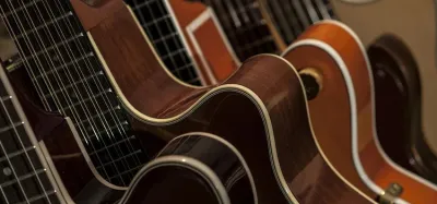 Several electric and acoustic guitars on stands in a home music room
