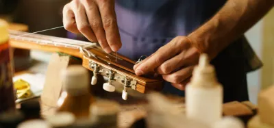 Close-up of a guitarist replacing a broken string on an acoustic guitar