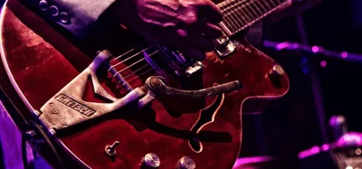 Electric guitarist dialing in a warm, smooth jazz guitar tone