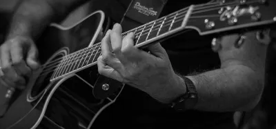 Guitarist practicing chords and scales to improve their playing