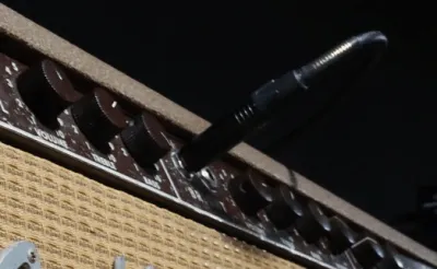 Electric guitar plugged into an amplifier producing feedback on stage