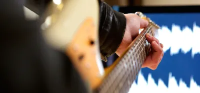 Guitarist using a loop pedal connected to an amplifier