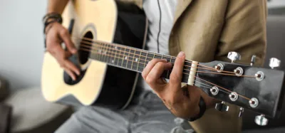 Musician playing an acoustic guitar with warm, clear tone
