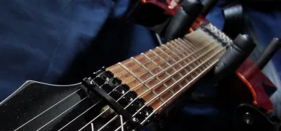 Close-up of a 7 string electric guitar fretboard showing the extra low string