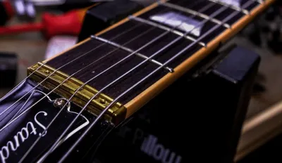 Guitar technician adjusting the action and intonation during a professional setup