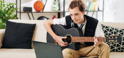 Beginner learning to play an acoustic guitar at home