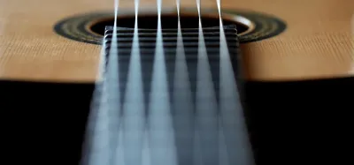 Close-up comparison of light gauge and medium gauge guitar strings