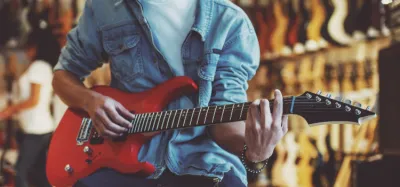 Guitarist playing beginner anime songs on an acoustic guitar