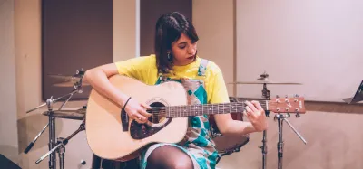 Beginner playing easy country songs on an acoustic guitar