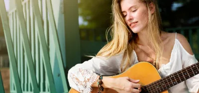 Person playing folk music on an acoustic guitar