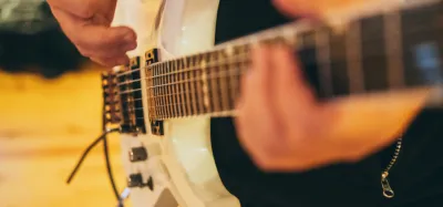 Guitarist playing a tight funk rhythm groove on an electric guitar