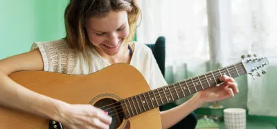 Person playing an electric guitar while learning a song by ear