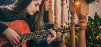 Beginner guitarist playing an easy song without a capo on an acoustic guitar