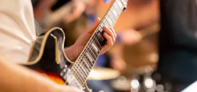 Person playing jazz chords on a hollow-body electric guitar