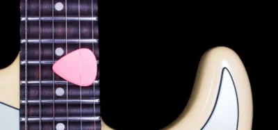 Close-up of a guitar neck with a scalloped fretboard showing the U-shaped dips between frets