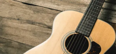 A Taylor acoustic guitar next to a Martin acoustic guitar for comparison