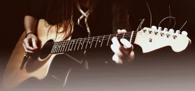 Excess guitar strings being trimmed at the headstock tuning pegs