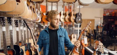 Several different types of acoustic guitars lined up in a shop
