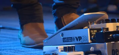 Volume pedal sitting in a guitar pedalboard signal chain