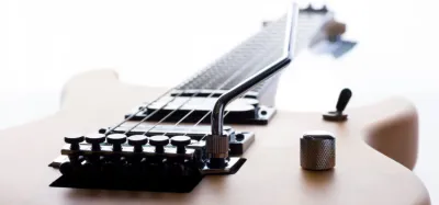 Whammy bar being removed from an electric guitar tremolo bridge