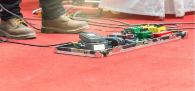 Guitar overdrive pedal on a pedalboard connected to a tube amp