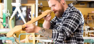 Guitar headstock with the truss rod nut exposed and an allen wrench ready to adjust it