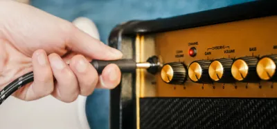 Guitar amplifiers of different sizes lined up, from small practice amp to large stack