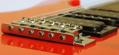 Close-up of a guitar bridge and saddle where string buzz commonly originates